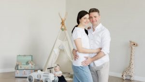A joyful family with a toddler in a cozy room with playful decor and a teepee.